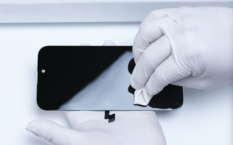 A gloved technician handling a replacement display during inspection