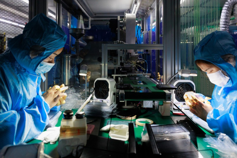 Technicians assembling mobile replacement displays in a Shenzhen production facility