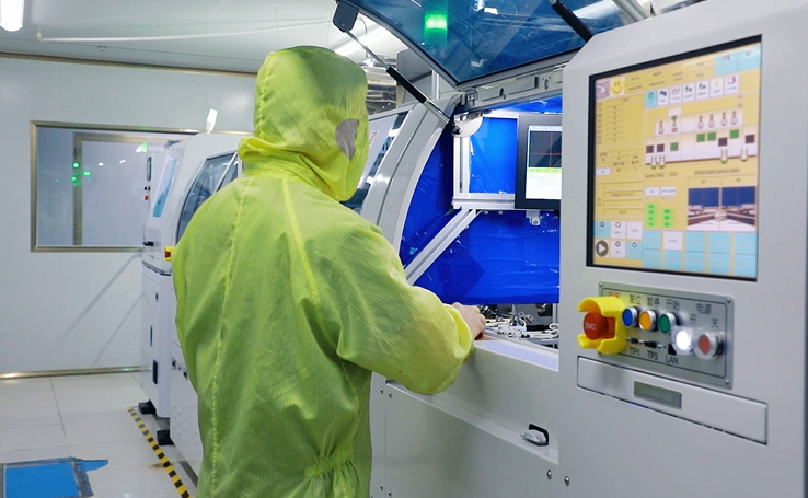 Technician inspecting components with a microscope